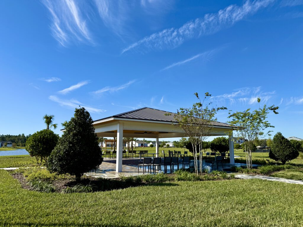 Covered picnic pavilion beside a lake with new landscaping