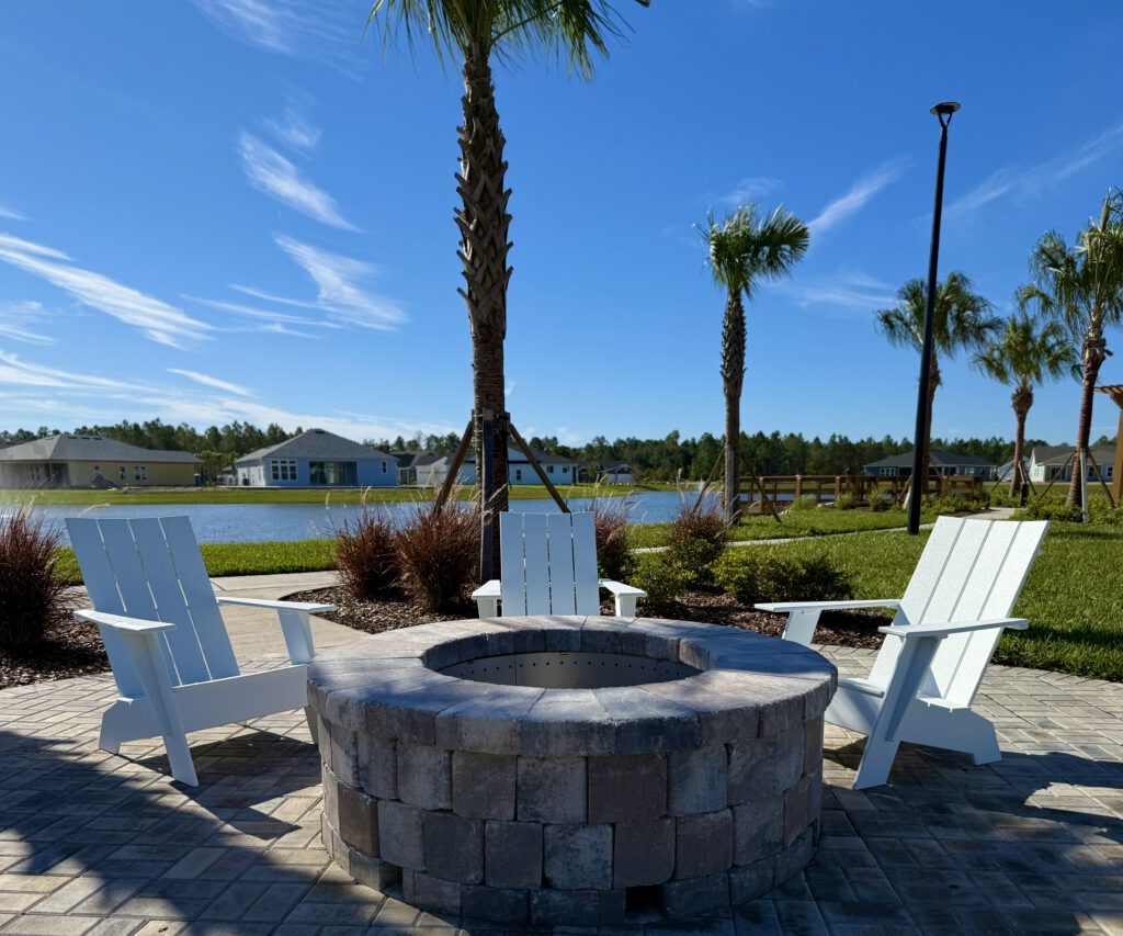 Paver fire pit with Adirondack chairs overlooking a lake