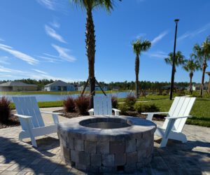 Paver fire pit with Adirondack chairs overlooking a lake