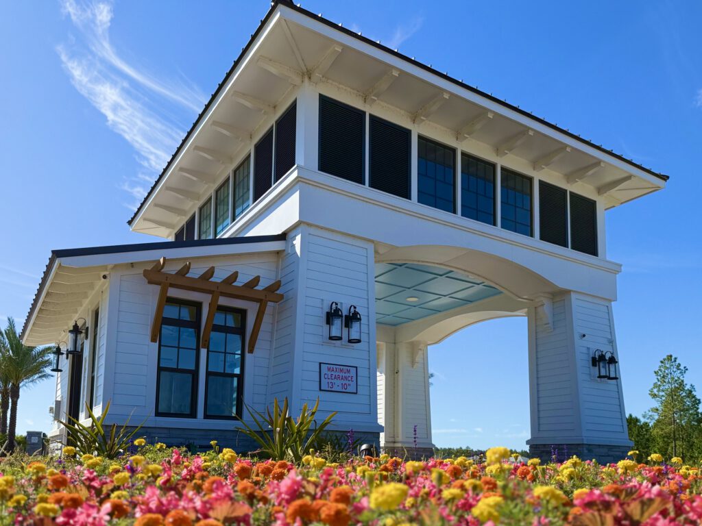Gatehouse entry pavilion framed by colorful flower beds