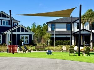 Community green with shade sail and lawn games