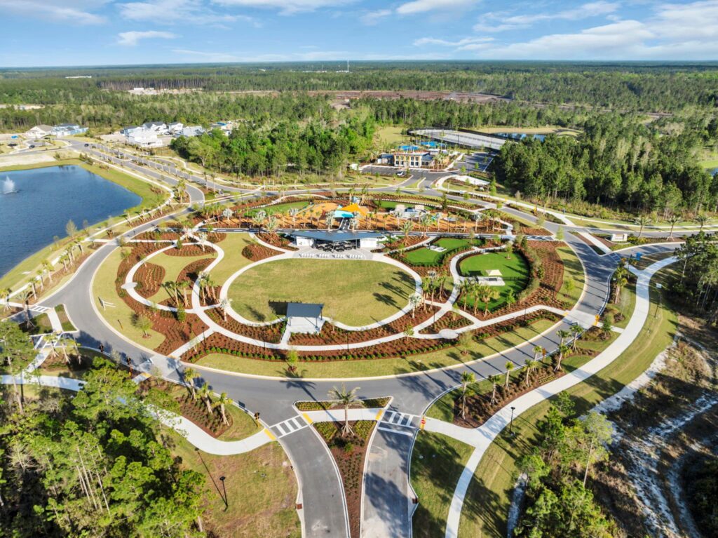 Aerial view of the Skipping Stone community park with lawn, pavilions, paths and lake