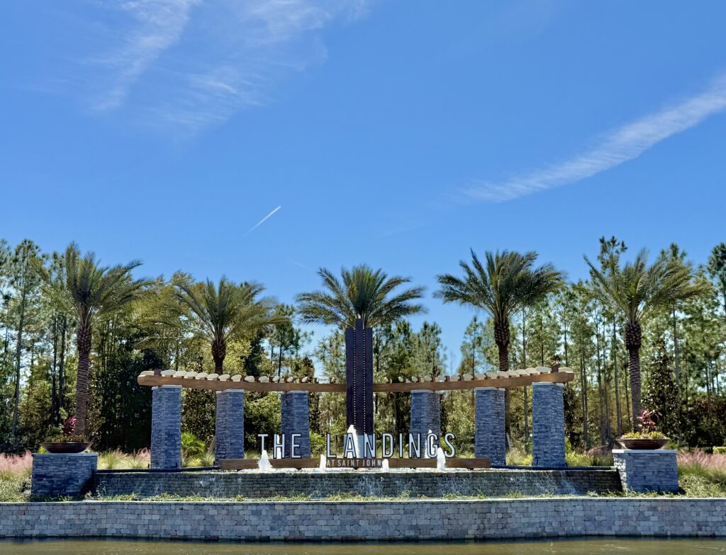 The Landings at St Johns entrance monument with stone columns, fountains and palms